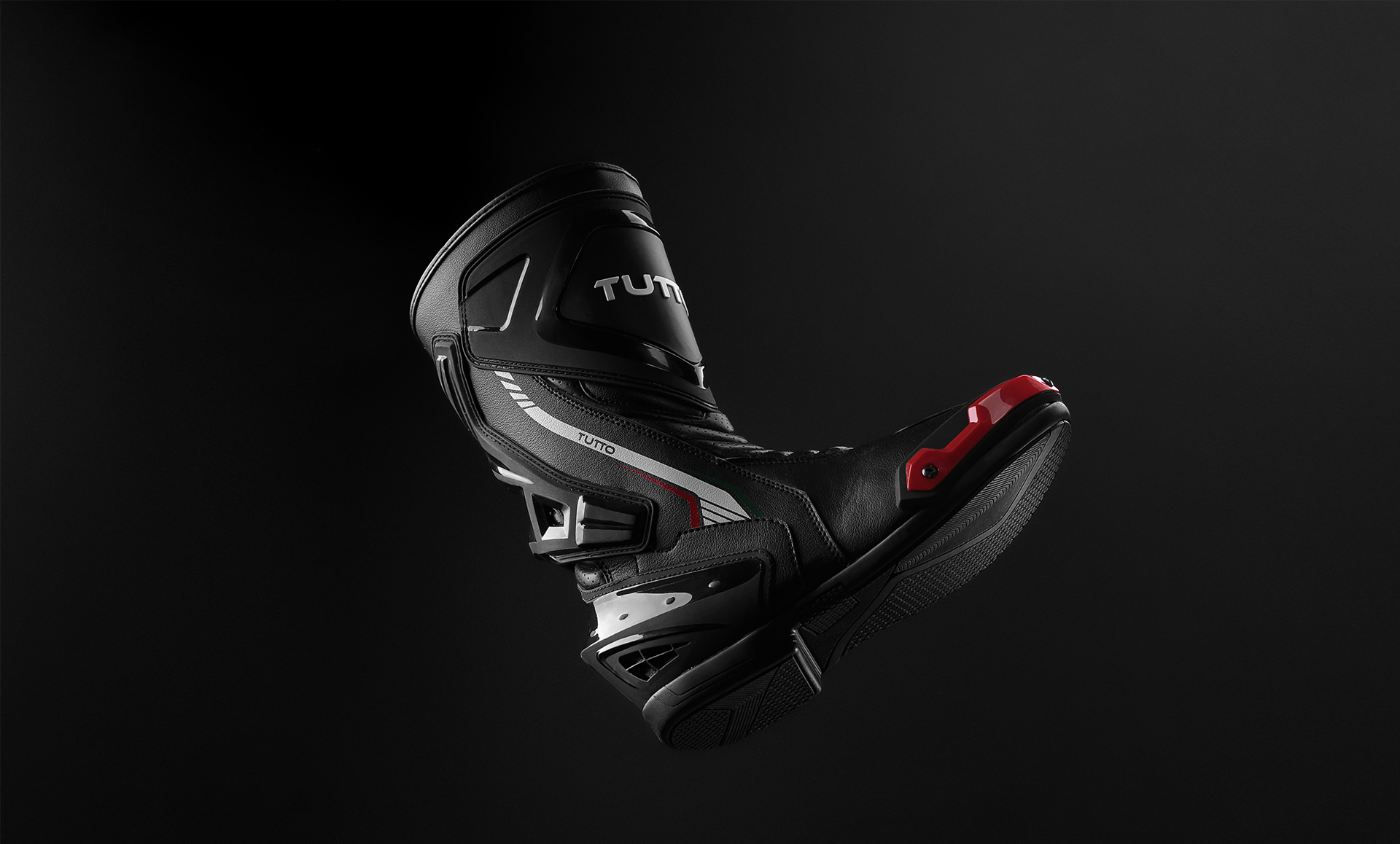 Bota esportiva preta fotografada em still com fundo escuro