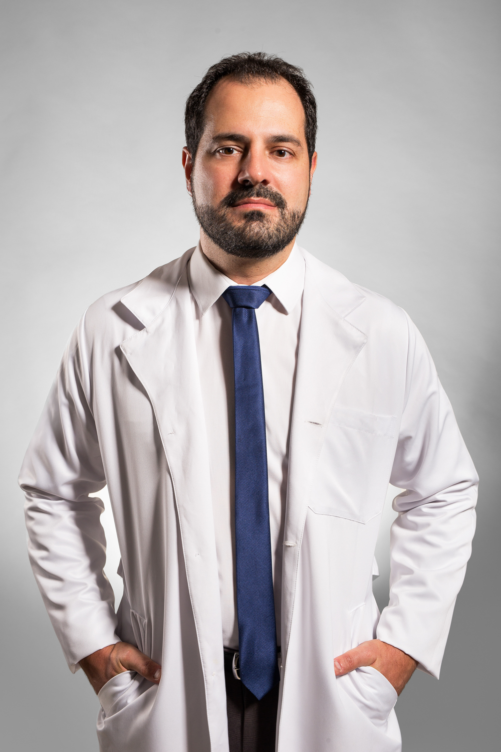 Retrato corporativo de médico de jaleco branco em fundo neutro