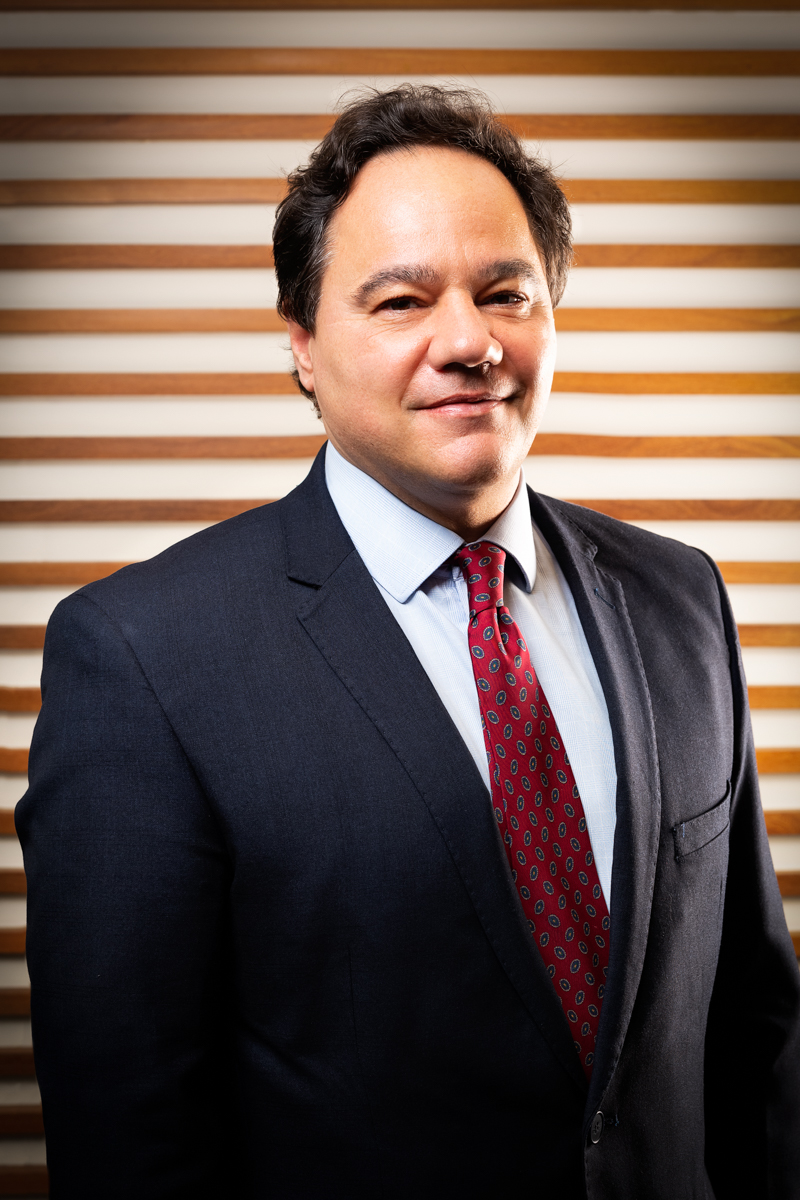 Retrato corporativo de executivo de terno e gravata em ambiente profissional
