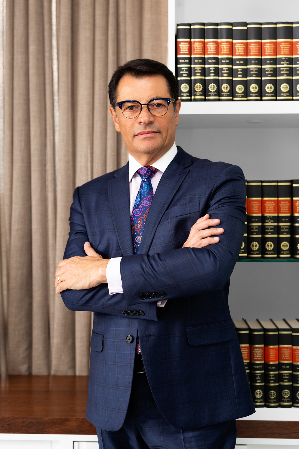 Retrato profissional de executivo com óculos, terno e gravata em escritório