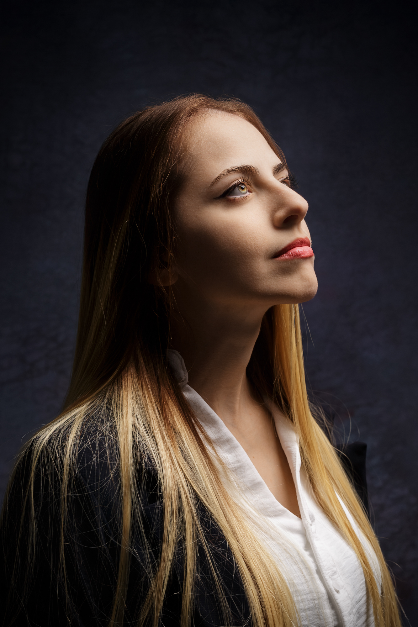 Retrato feminino de perfil com iluminação lateral em estúdio