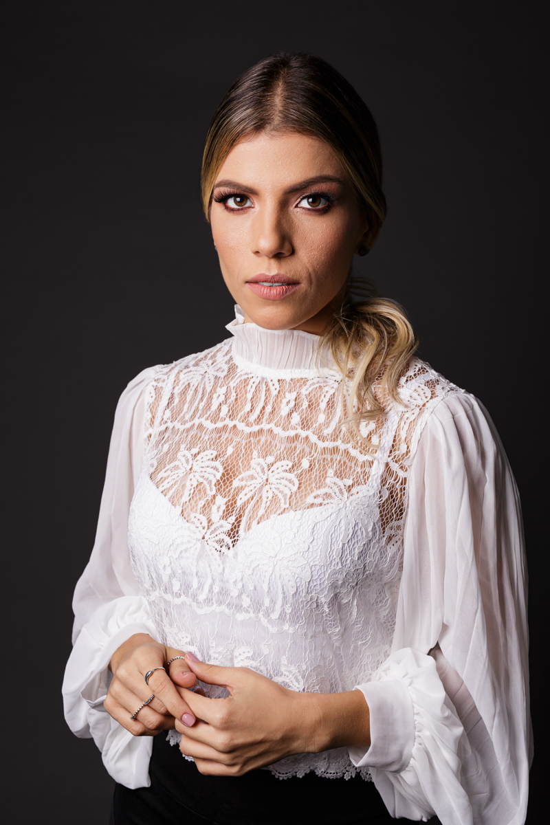 Retrato feminino em plano fechado com maquiagem e fundo escuro