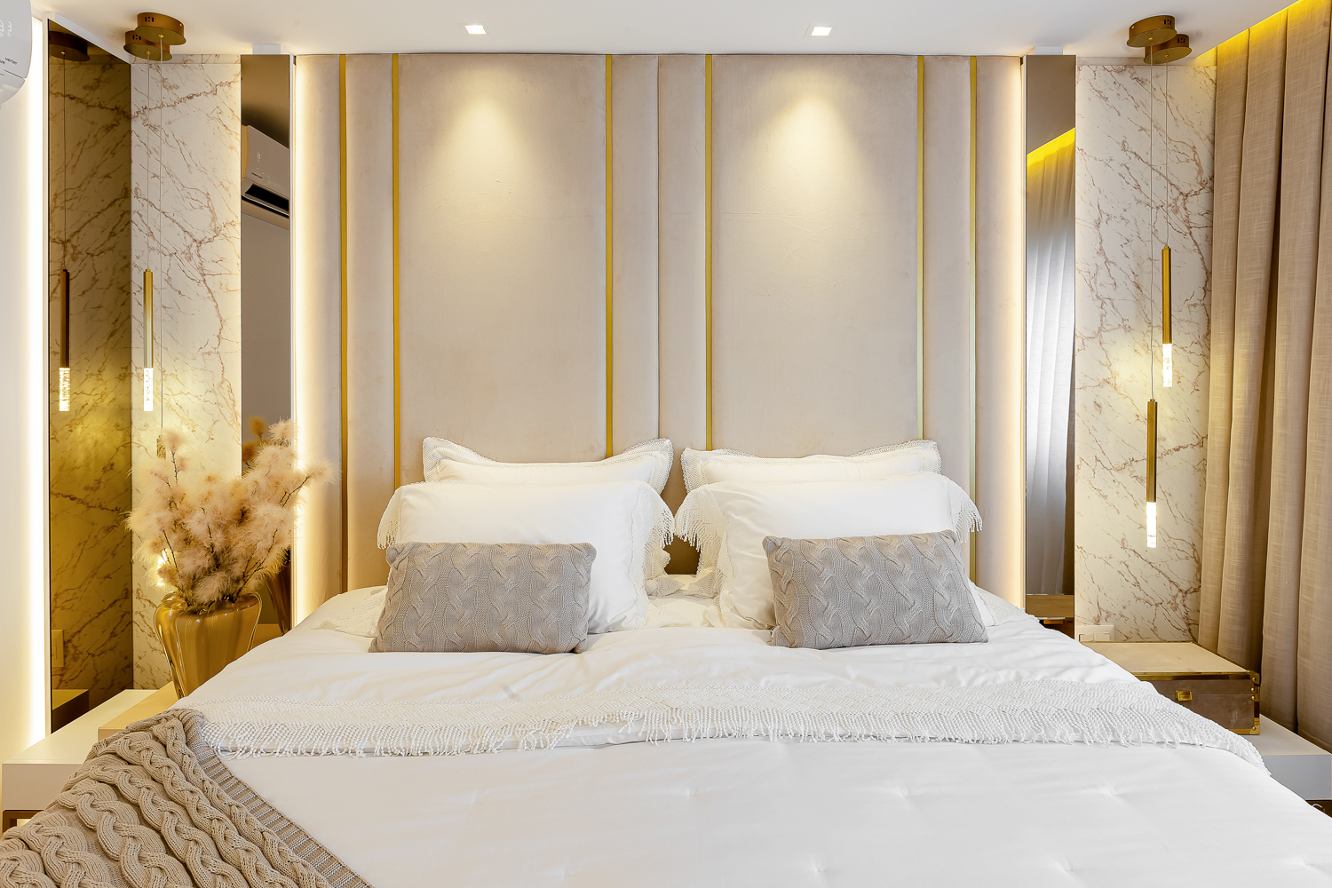 Quarto contemporâneo com cama central, cabeceira iluminada e cortinas claras.