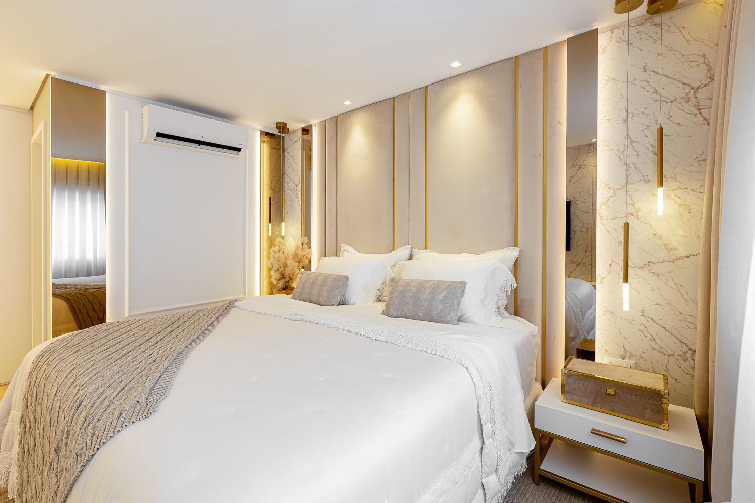 Quarto contemporâneo com cabeceira estofada, iluminação indireta e acabamento claro.