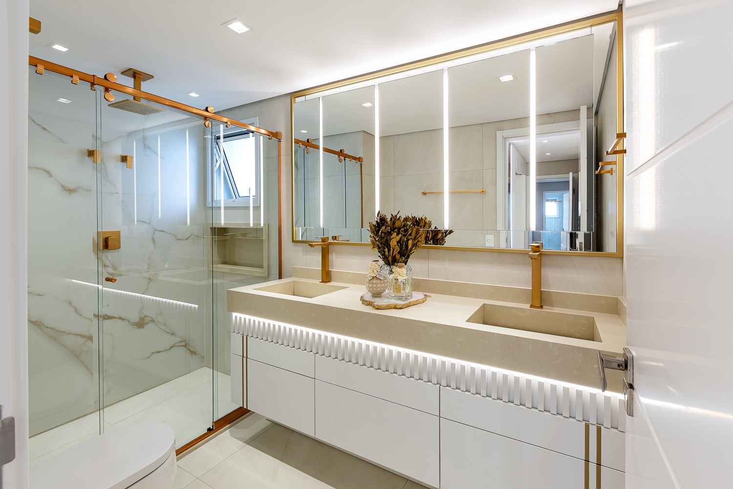 Suíte contemporânea com cama, armários com portas de vidro e iluminação natural.