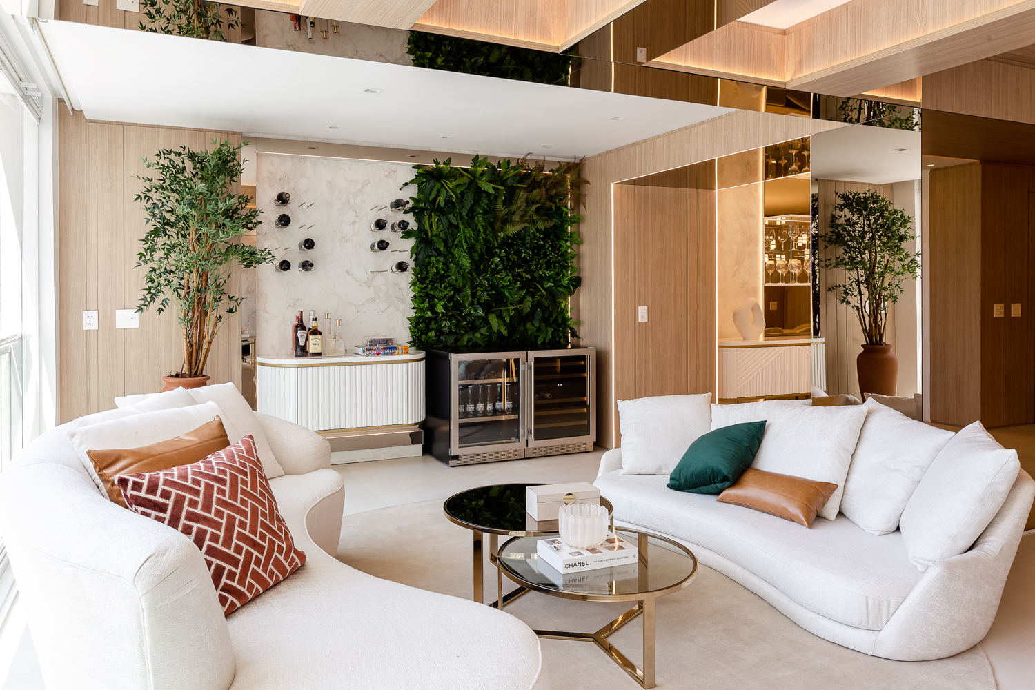 Sala de estar integrada com lareira, marcenaria clara e jardim vertical.