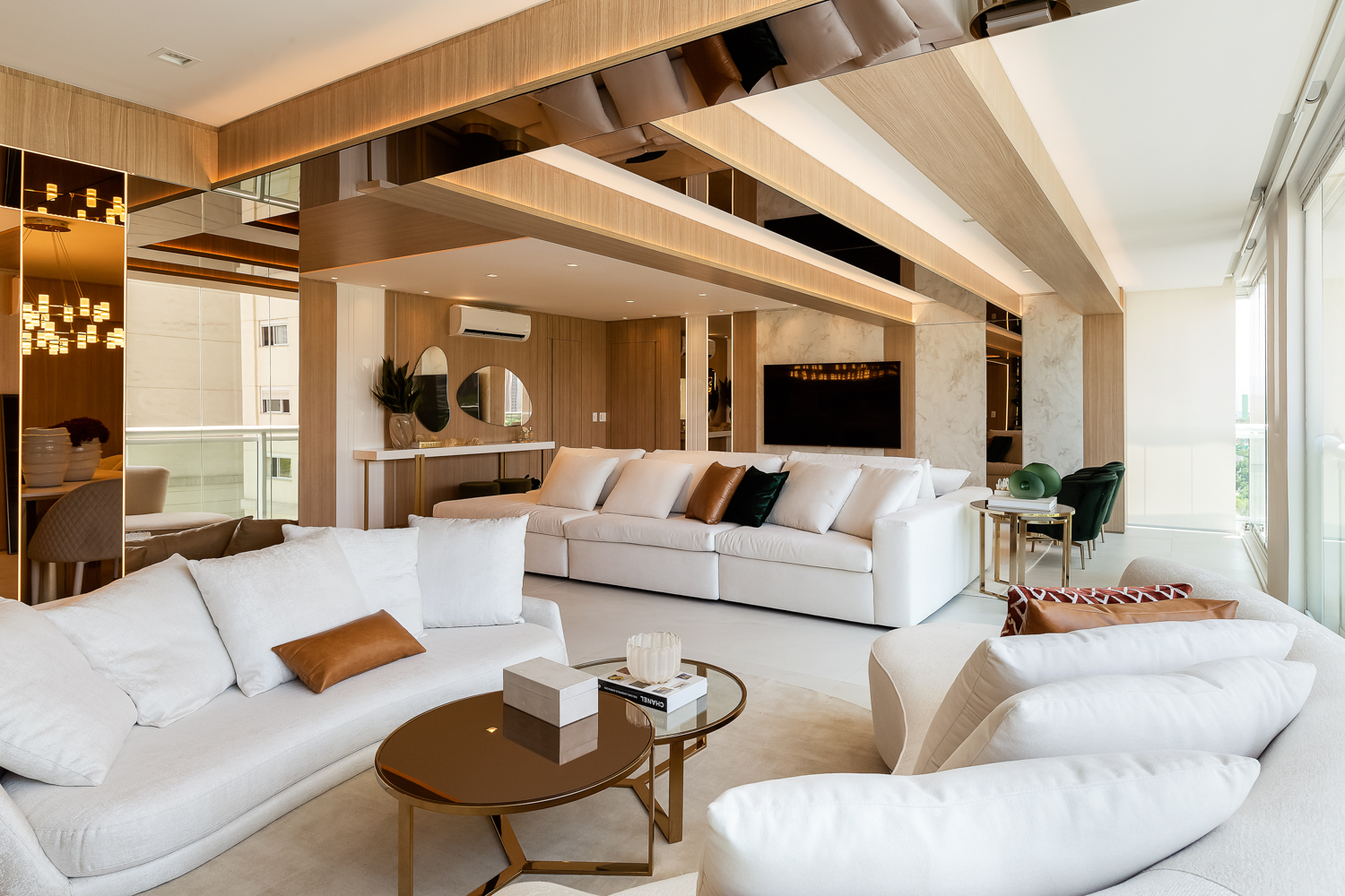 Suíte contemporânea com teto em madeira, cama central e iluminação natural.