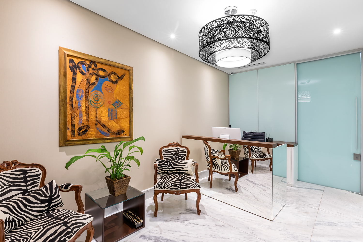Sala de jantar contemporânea com mesa redonda, obra de arte e luminária pendente.